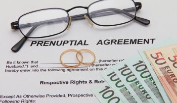 Prenuptial Agreement form and two gold wedding rings