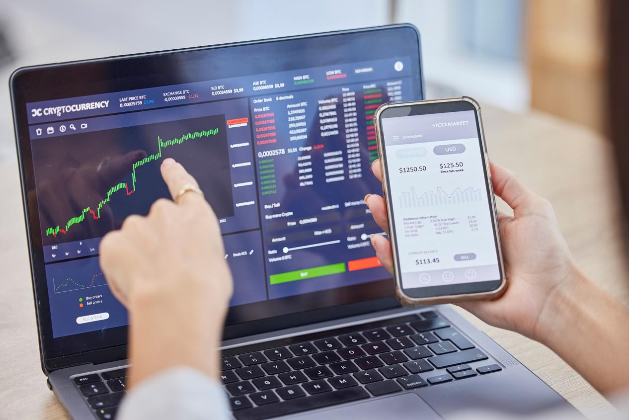 Màn hình điện thoại di động, máy tính xách tay và thị trường chứng khoán giao dịch bằng tay cho fintech, đầu tư hoặc tiền điện tử tại văn phòng. Điện thoại thông minh, giao diện người dùng và nữ doanh nhân sử dụng số liệu thống kê hoặc biểu đồ đầu tư điện thoại di động.