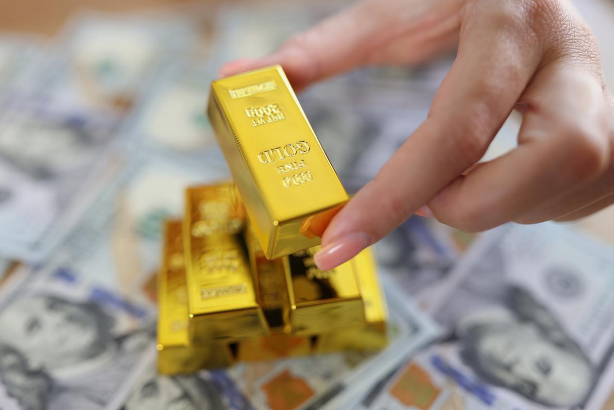 背景に現金で小さな金のインゴットを持つ女性position_newest_0_resourcebtn&